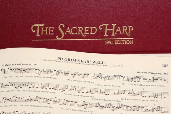 The cover of a copy of The Sacred Harp tunebook with a page of music (the song Pilgrim's Farewell, page 185) overlaid across it. This is the tunebook we use most frequently at this Sacred Harp singing.